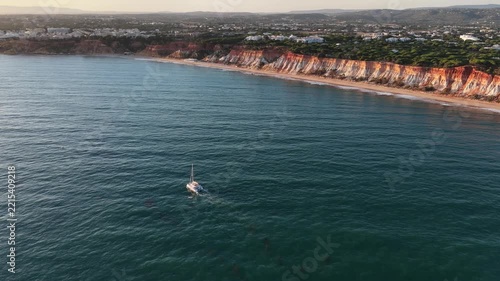 Aerial view of sailing luxury yacht at opened sea at sunny day in Algarve, Portugal, Sunset