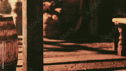 In a cozy tavern setting, warm light highlights aged wooden barrels and rustic furniture, creating a welcoming atmosphere. The scene evokes a sense of history and comfort.