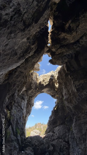 Adventure exploration of deep karst caves and rocky arches in remote mountains
