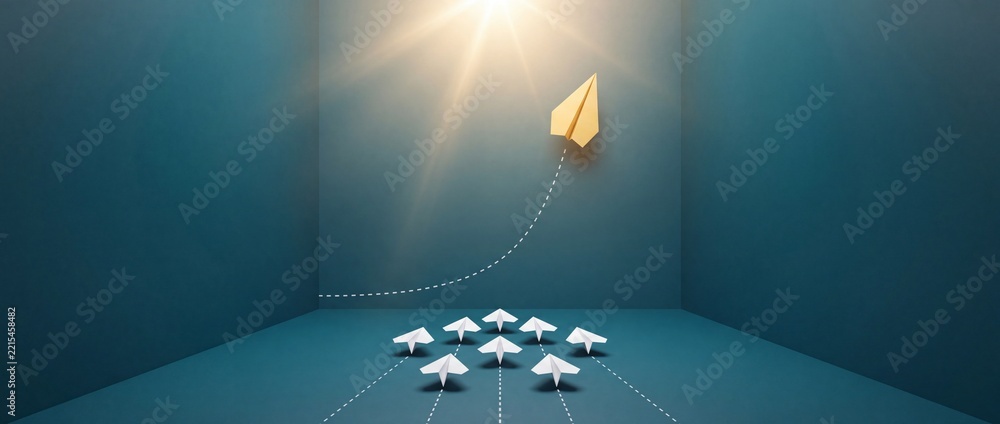 Fototapeta premium Conceptual representation of a yellow paper airplane changing direction and flying upwards toward light, symbolizing leadership, innovation, and a perspective shift in a business environment.