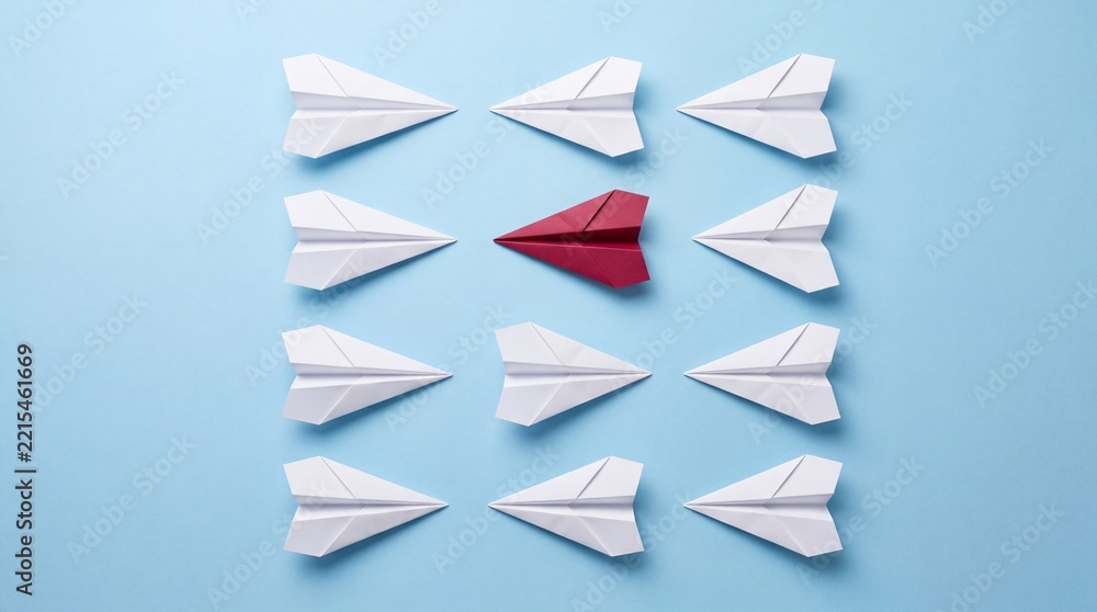Fototapeta premium Top Down View of a Single Red Paper Plane Pointing One Direction While White Paper Airplanes Point Towards the Opposite Sides on a Light Blue Background, Concept of Leadership and Individuality