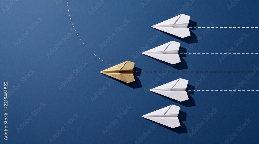 Fototapeta premium Gold paper plane changing direction and leading a group of white paper planes on blue background, metaphor for leadership, innovation, unique business strategy, and being different.