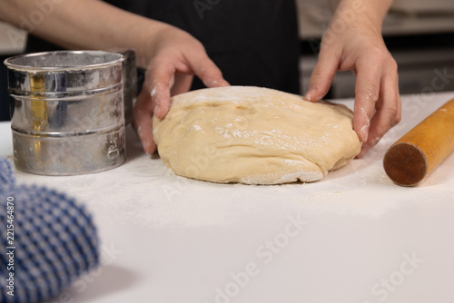 Obraz na plátně Hands preparing homemade sufganiyot dough beside a flour sifter