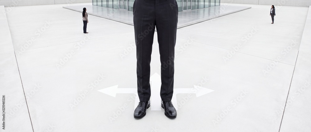 Fototapeta premium Businessman standing at a crossroad with white arrows pointing in three different directions, representing professional decision making, career path choices, and strategic planning in corporate life.