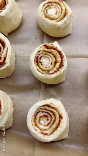Deliciously Swirled Cinnamon Rolls Ready for Baking: Perfectly Bent and Waiting to Rise on a Baking Sheet with Warm, Sweet Aroma Filling the Air