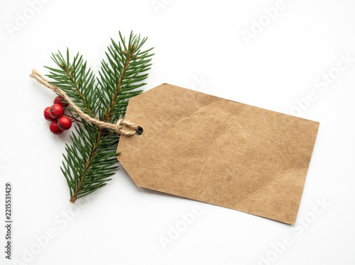 Brown gift tag with pine branch and red berries
