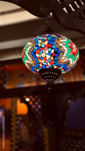 Traditional mosaic glass hanging lamp glowing in a restaurant interior