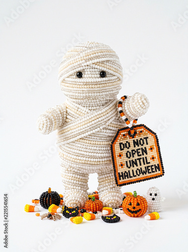 Beaded mummy holding Do Not Open Until Halloween gift tag