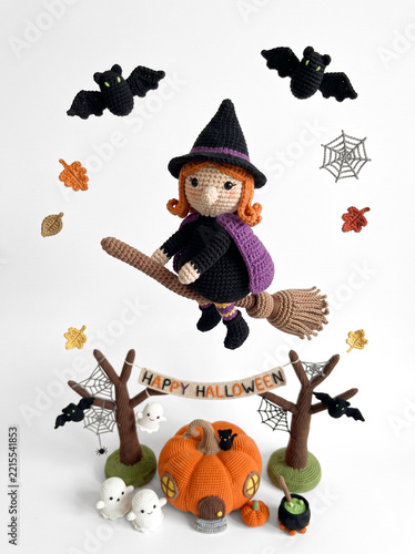 Crochet witch flying on broomstick over Happy Halloween garland