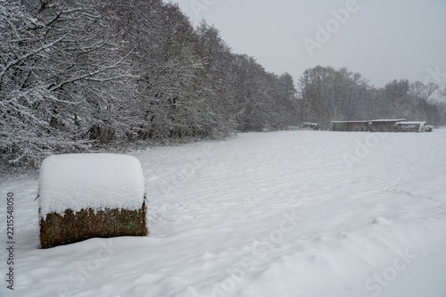A hay bale in the countryside with lots of snow.