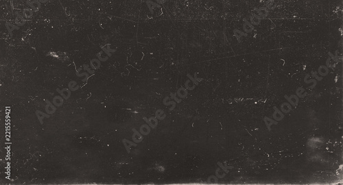 Dark vintage film texture with dust, hair fibers, fine scratches and aged surface imperfections in a deep brown black tone.