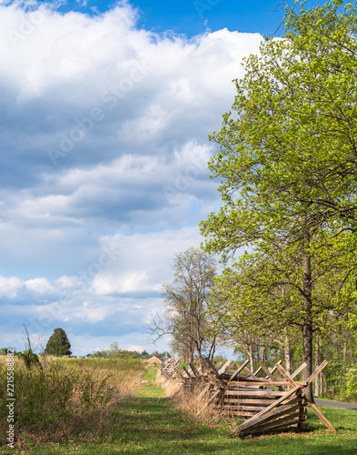 Historic split-rail fence crosses the spring landscape at Gettysburg National Military Park in Pennsylvania on a sunny day