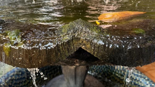 Water Cascading Over Mossy Stone Fountain Tier Slow Motion 4K Footage