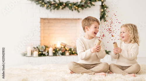 Two children celebrating with confetti in a cozy holiday setting  
