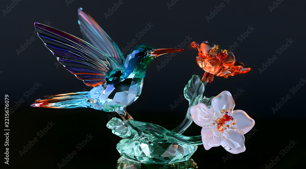 Fototapeta premium Crystal hummingbird sculpture with glass blossoms