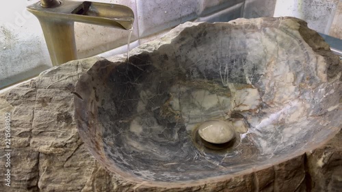 Bathroom sink and running water from the tap