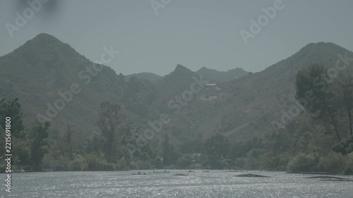 Hazy layered mountains over a forested valley and riverbed