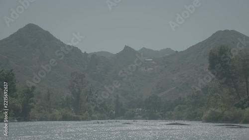 Softly lit mountain peaks behind trees and a dark valley floor
