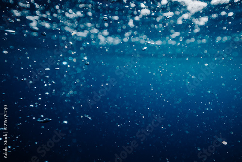 bubbles drifting beneath the dark ocean surface