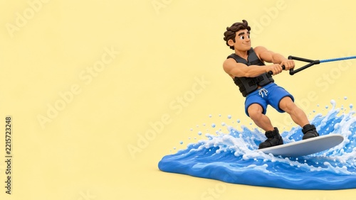 Clay style wakeboarder holding a tow handle above blue waves on yellow