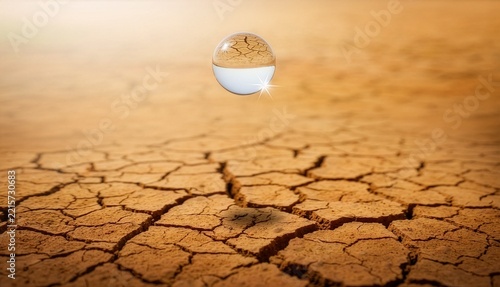 乾いた大地に落ちる一滴の透明な水と水不足を象徴する写真