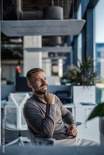 Confident businessman smiling in a modern office workplace