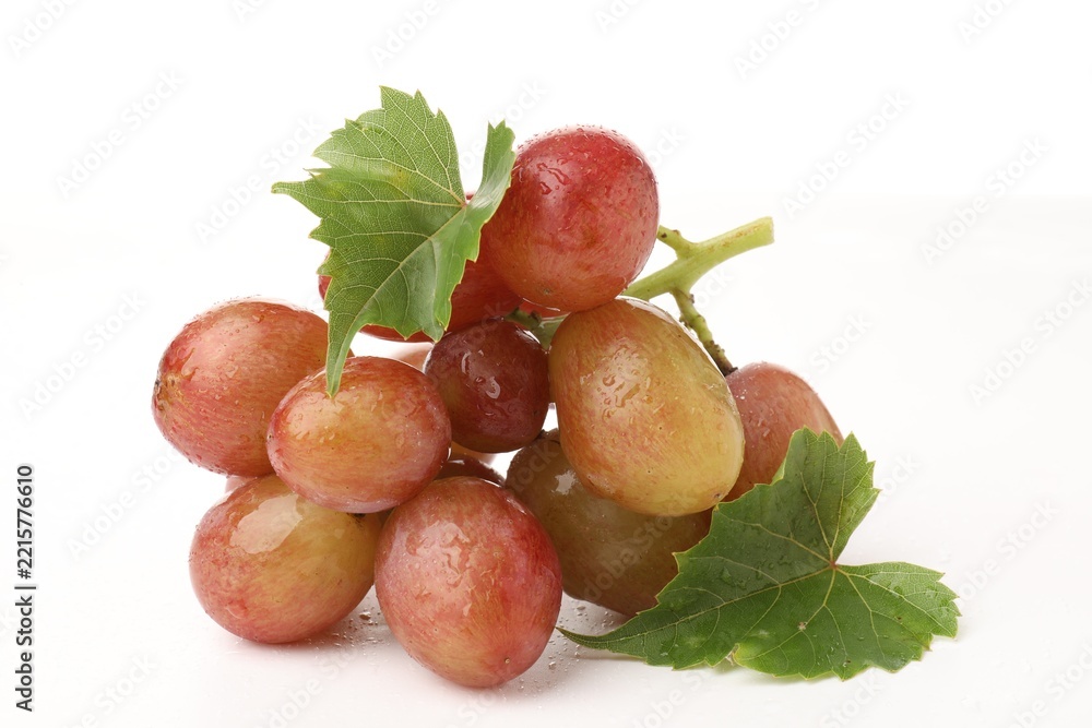 Naklejka premium Bunch of fresh ripe grapes with green leaves on white background