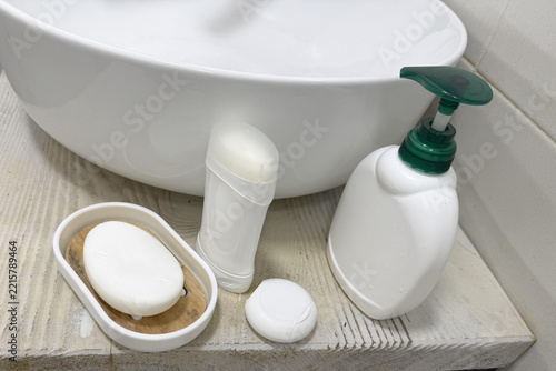 White bathroom sink and toiletries on a rustic wooden countertop