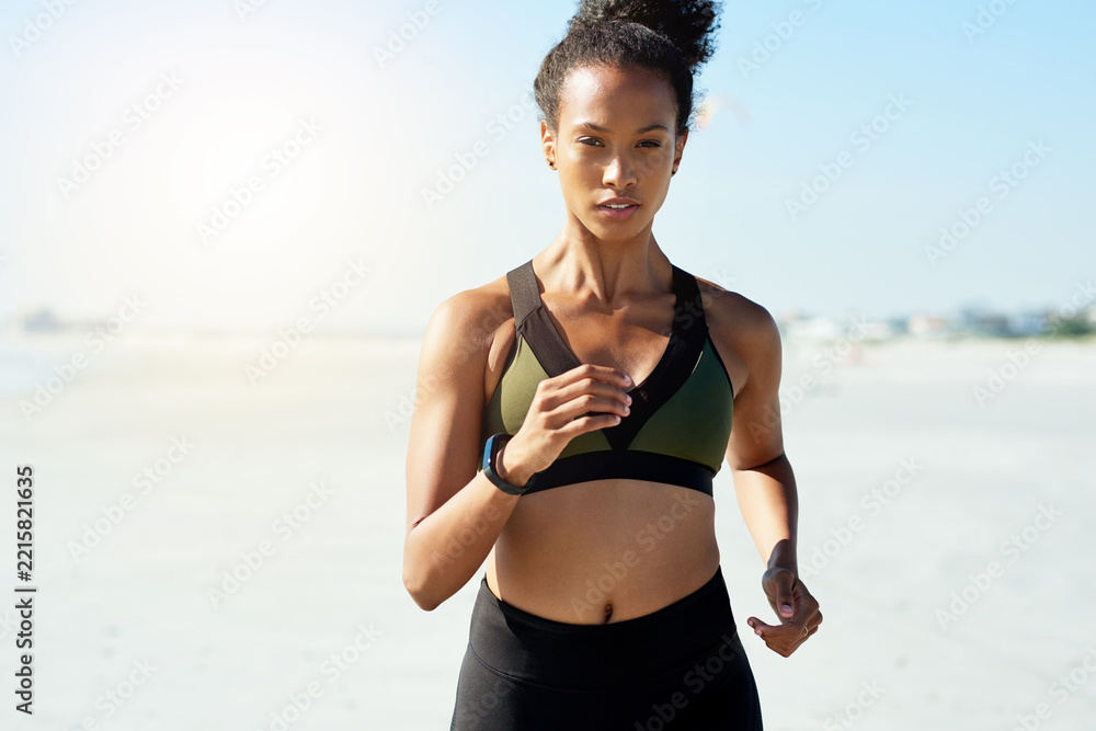 Naklejka premium Fitness, running and portrait with woman on beach for cardio training or morning workout. Blue sky, exercise and health with African athlete or runner on space outdoor for challenge or improvement