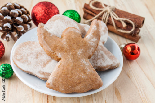 Christmas angel cookie decorated with icing, Christmas baubles, cinnamon sticks and pine cone
