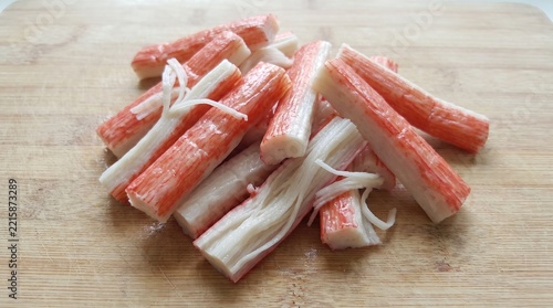 Fresh imitation crab sticks on a wooden cutting board