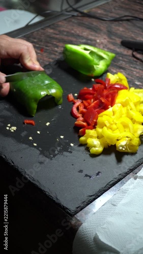 Closeup, person cutting a green pepper.