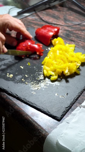 Closeup, person slicing a red pepper