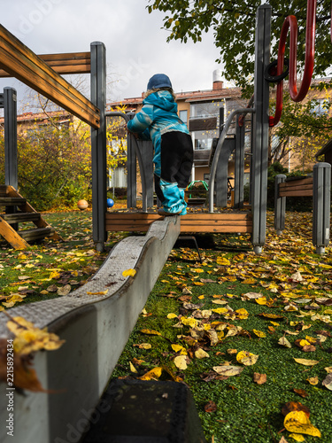 Young Child Exploring Playground Independently in Autumn
