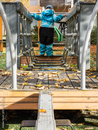 Young Child Crossing Playground Rope Bridge
