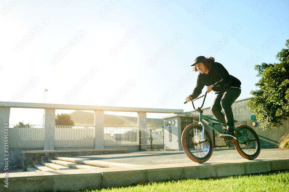 Naklejka premium BMX, man and bicycle in city for cycling, urban challenge and exercise with mockup space. Person, riding bike and cyclist on curb outdoor for fitness, extreme sports or action for balance with cardio