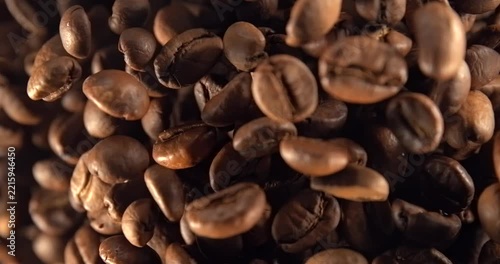 Roasted coffee beans falling in super slow motion 1000 fps macro top view