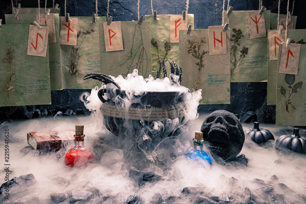 Fototapeta premium Spooky skull stands beside a steaming cauldron.