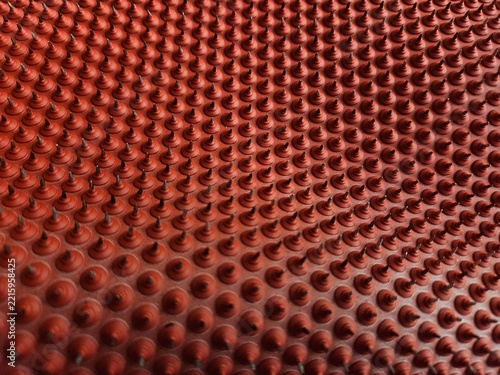 Red textured surface with evenly spaced raised circular bumps. Patterned design shows uniform, glossy, rounded protrusions. Close-up view highlights depth and repetition of the textured surface