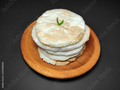 Palembang Kemplang Crackers with Garnish Served on Wooden Plate and Dark Background.
