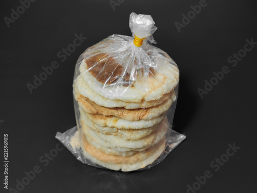 Take Away Street Food of Palembang Kemplang Crackers with Dark Sauce in Plastic Wrap.