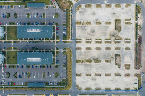 Aerial view of identical suburban houses in a residential community with paved parking lots and an adjacent undeveloped construction site in Jacksonville, Florida, United States.
