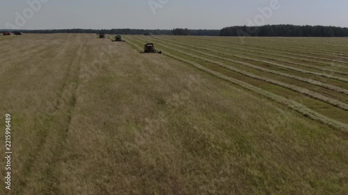Drone flies forward toward working combines, D-Log