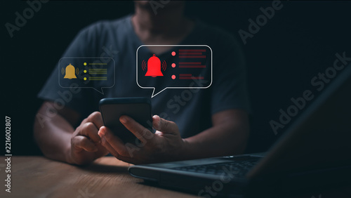 Digital notification alert concept. Person using smartphone with warning bell messages. Mobile reminders, urgent updates, system notices, communication, attention and online user engagement.