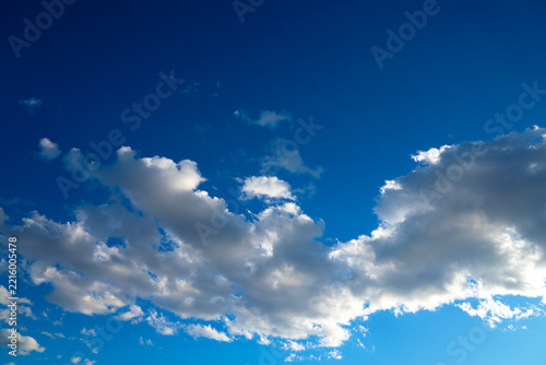 Fotografie A serene and vibrant blue sky filled with fluffy white clouds, capturing a bright, peaceful daytime atmosphere ideal for various creative and commercial projects
