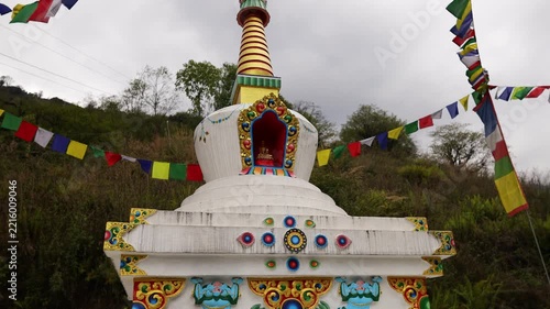 Colorful Buddhist prayer flags flutter gently above a sacred stupa in Nepal, creating a serene spiritual atmosphere in the Himalayan landscape. Traditional Tibetan flags display vibrant colors