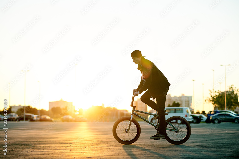 Naklejka premium Balance, BMX and ride with man on bike in city for activity, adrenaline hobby or sports training. Exercise, flare and risk with extreme person on bicycle on street for action, cycling or energy