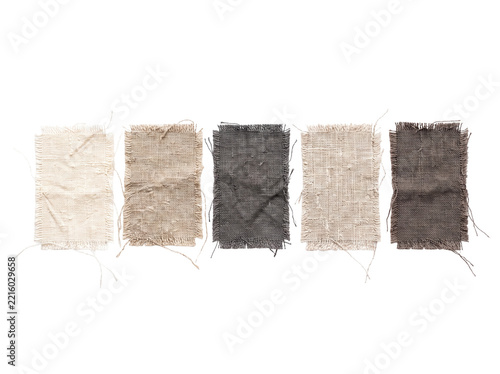 Linen fabric swatches canvas samples in neutral earth tones arranged horizontally on black background with frayed raw edges and textured coarse weaving for interior design moodboards and mockups.