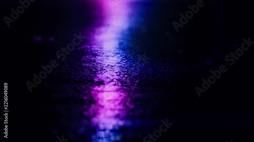 Rain On The Ground At Night Reflects Neon Lights
