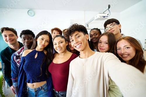 Happy multiethnic students taking a selfie in classroom